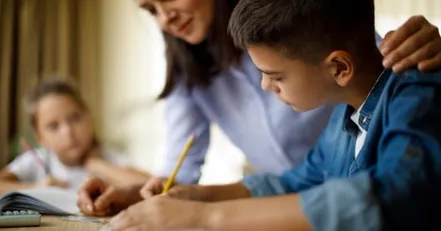 Mother helping her children with homework