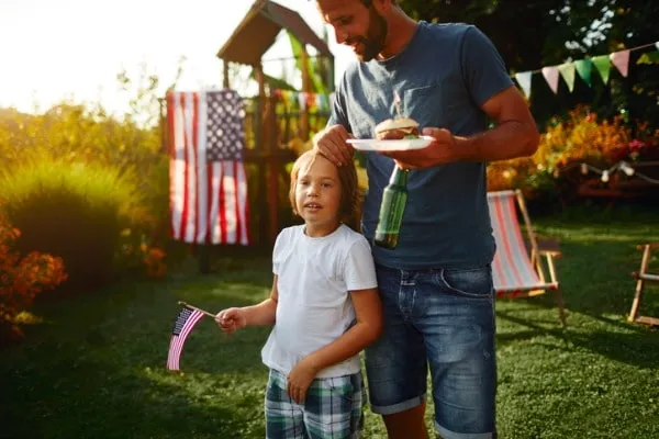Father and son with hamburgers and American flags