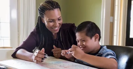 Mother teaching special needs child to draw