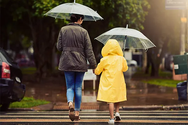 Mother walking in rain with daughter