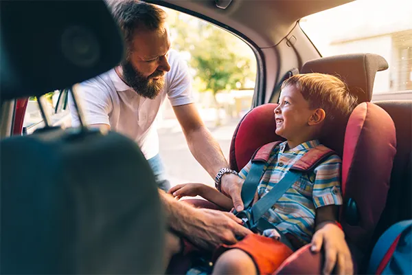 Father putting child into a car seat
