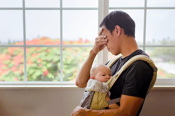 Frustrated father holding infant