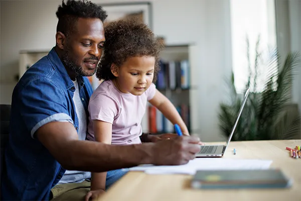 Father completing form on his computer