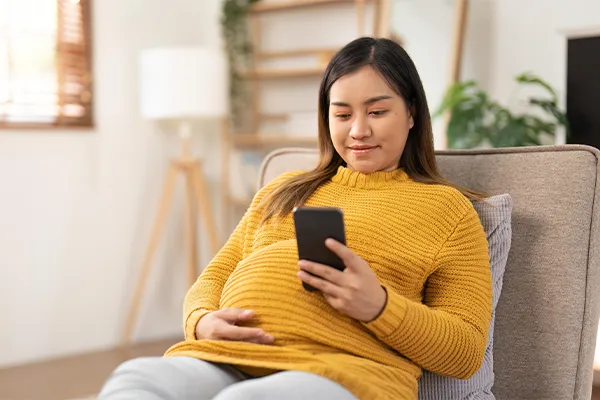 Pregnant woman looking at her phone