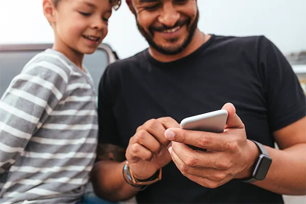 Happy father and son looking at a cellphone