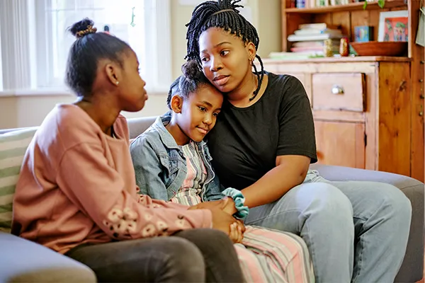 Mother consoling two daughters