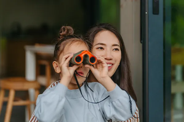 Mother bird watching with her young daughter