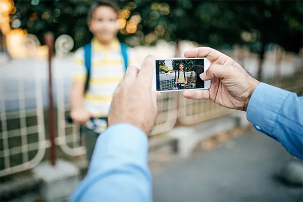 Father taking a photo of his son