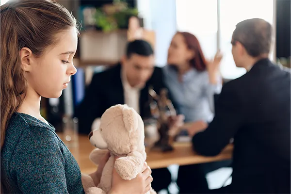Co-parents talking to a parenting coordinator with sad child