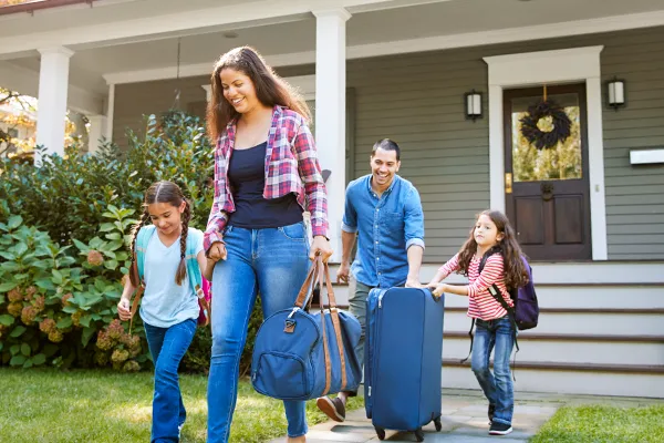 Co-parents carrying bags to car during child drop off