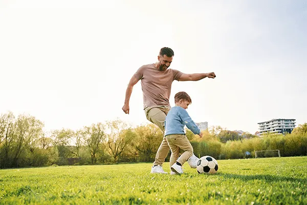 Father playing soccer with his son