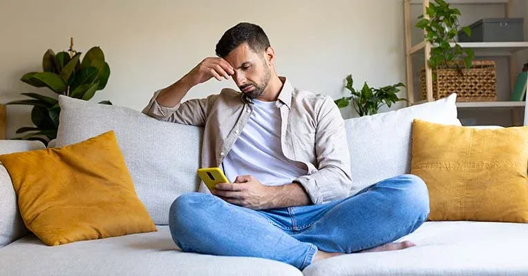 Stressed man looking at phone