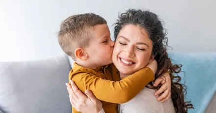 Little boy kissing his mother on the cheek