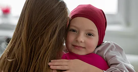 Child with cancer hugging mother