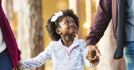 Parents holding child’s hand