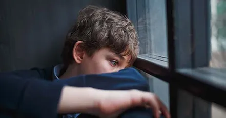Sad boy looking out window