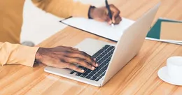 Man journaling on a computer