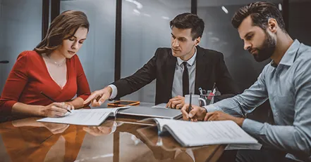 Co-parents signing documents with a lawyer