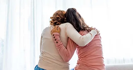 Mother hugging daughter
