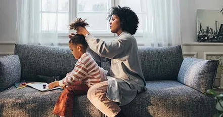 Mother doing daughter’s hair