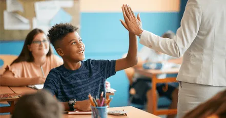 Child high-fiving teacher