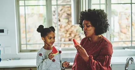 Mother and daughter eating watermelon