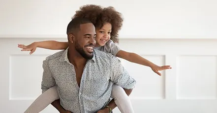 Father carrying daughter on his back