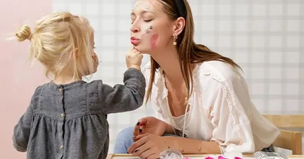 Mother letting daughter put makeup on her