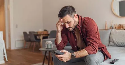 Frustrated man looking at his phone