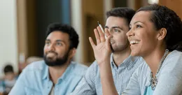 Person holding hand up in class