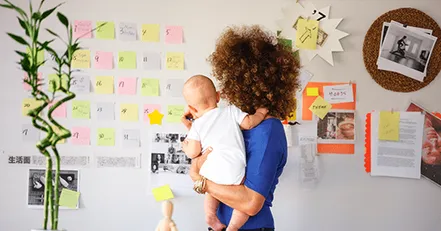 Mother holding baby looking at calendar