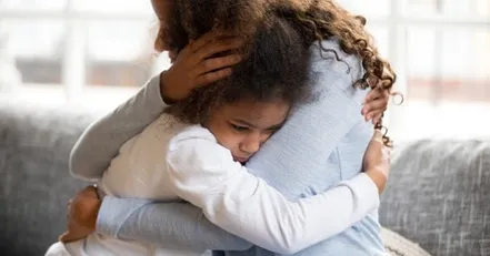 Mother hugging crying daughter