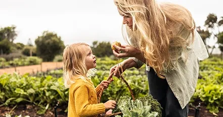Mother and daughter harvesting vegetables