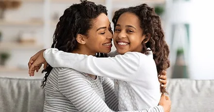 Mother hugging daughter